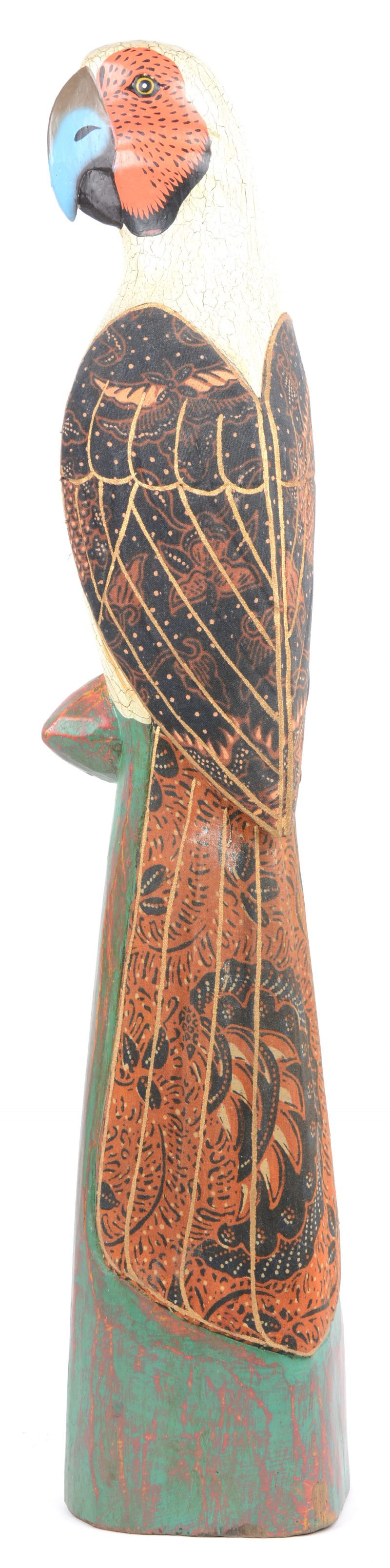 Een gepolychromeerde houten papegaai, bekleed met gebatikte stof.