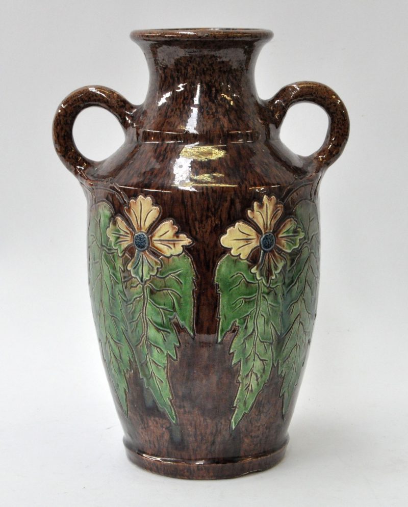 Vaas van Vlaams aardewerk met meerkleurig disteldecor in reliëf op bruine fond.
