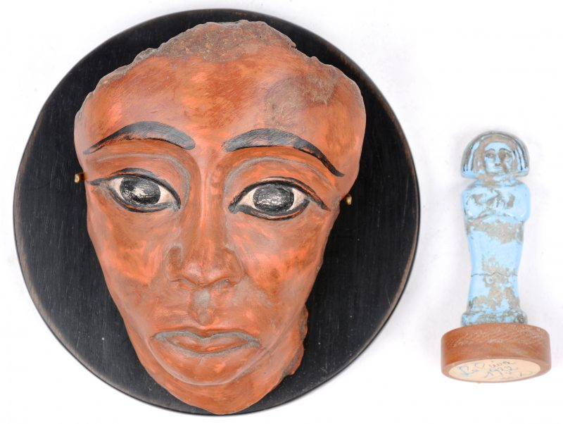 Twee souvenirs uit Caïro, bestaande uit replica’s van een dodenmasker en een kleine Ushepti (grafbeeldje). Begin jaren ‘30.