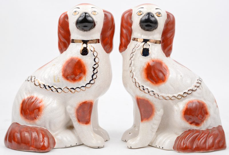 Een paar hondjes van meerkleurig aardewerk van Staffordshire.