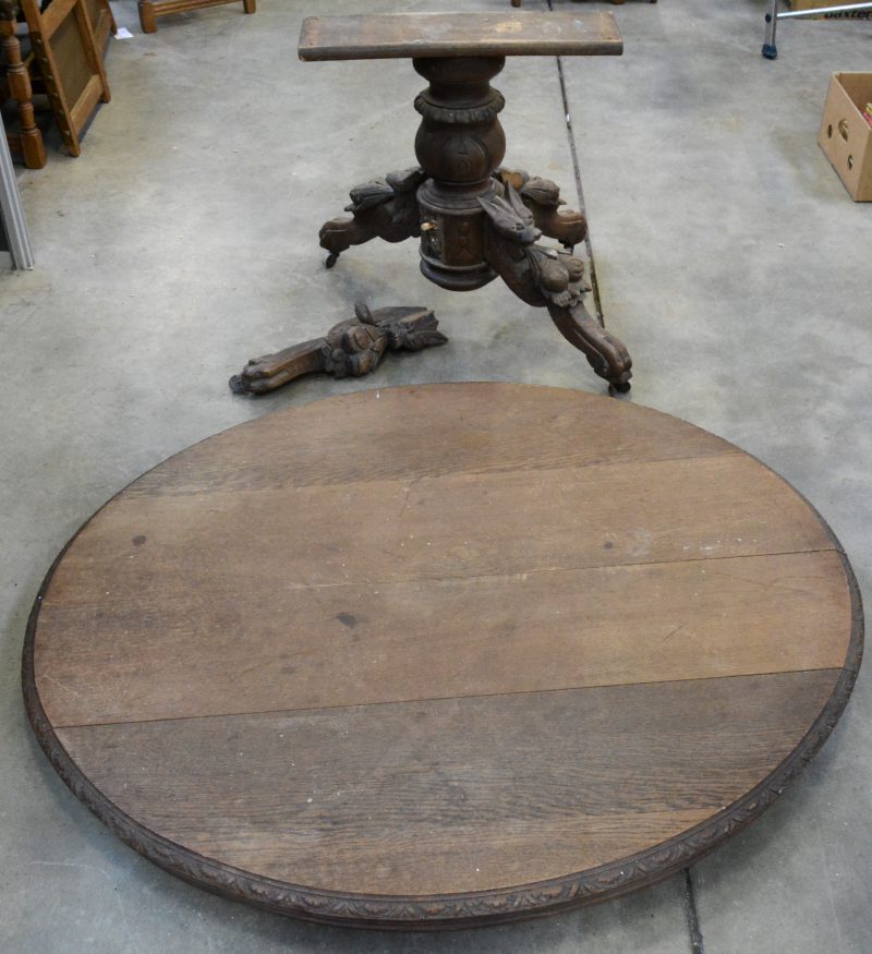 Een ovale tafel van gebeeldhouwd eikenhout, de poot versierd met dierenkoppen en vruchten. Poot te restaureren.