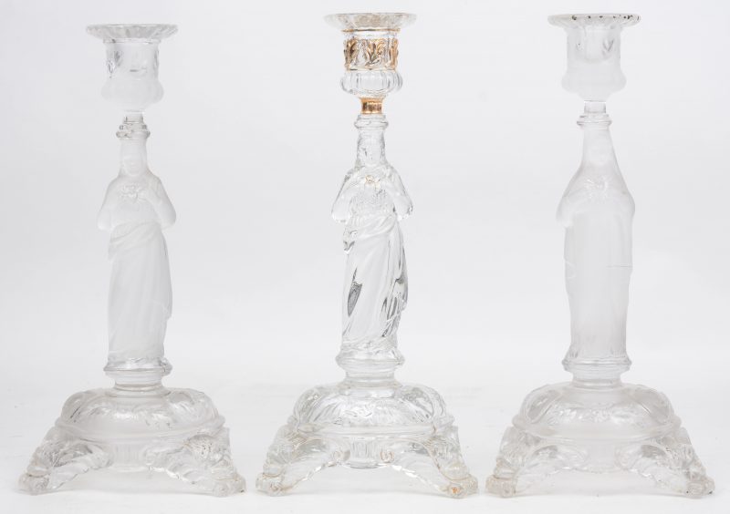 Drie glazen kandelaars met beeltenissen van Christus en Maria Heilig Hart, waarvan twee gesatineerd. Eén met barst.