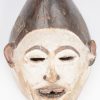 Twee deels witgepatineerde Afrikaanse houten maskers.