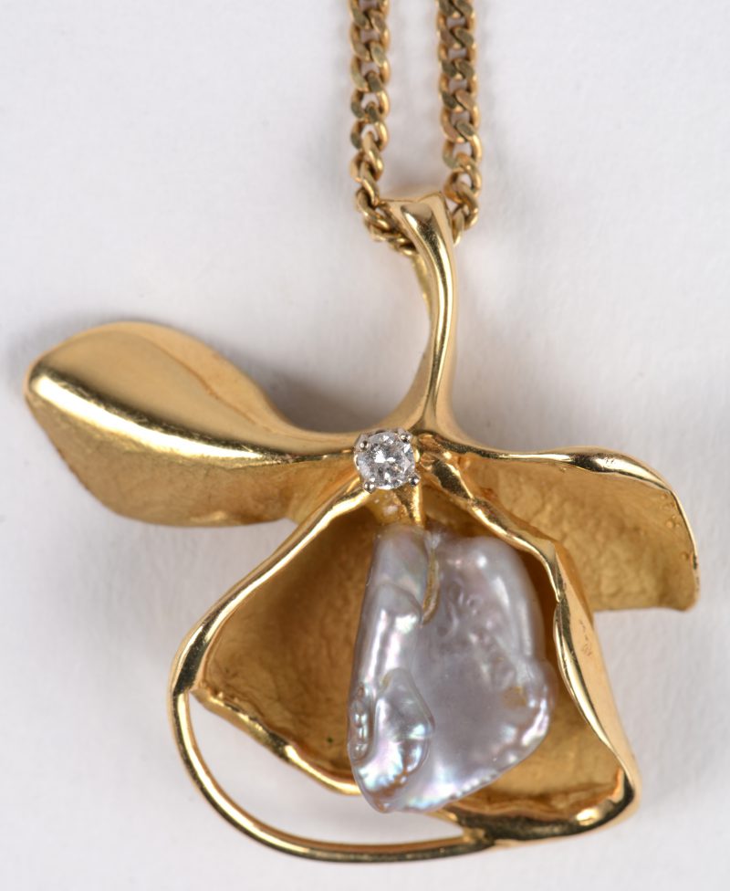 Een geelgouden ketting met bloemvormige hanger 18 K. Bezet met een natuurparel en een kleine diamant.