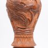 Een lot gebeeldhouiwde houten voorwerpen en beelden, bestaande uit een Afrikaanse buste, een Afrikaanse asbak met drie hoofden, een Indische bosbouwer op olifant (lichte schade aan de kettingschakels), een siervaas met drakendecor en een sierbord.