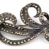 Een ring en twee broches van zilver bezet met amethist en markasiet.