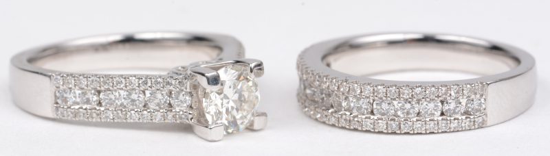 Twee witgouden ringen 18 K bezet met een centrale diamant van +- 0,82 ct. FSI1 en briljanten met een gezamenlijk gewicht van +- 1,24 ct.