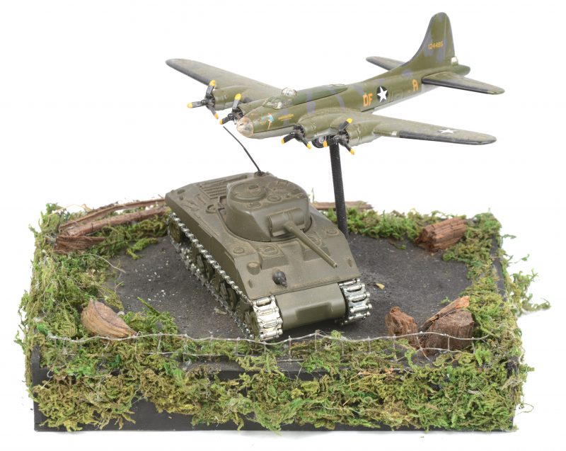 Een maquette met een vliegtuig en een Shermantank.