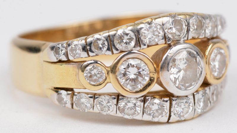 Een 14 K wit en geelgouden ring bezet met diamanten met een gezamenlijk gewicht van +- 1 ct.