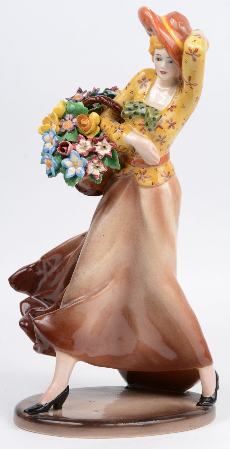 “Dame met bloemenmand”. Een beeld van meerkleurig aardewerk. Gesigneerd.