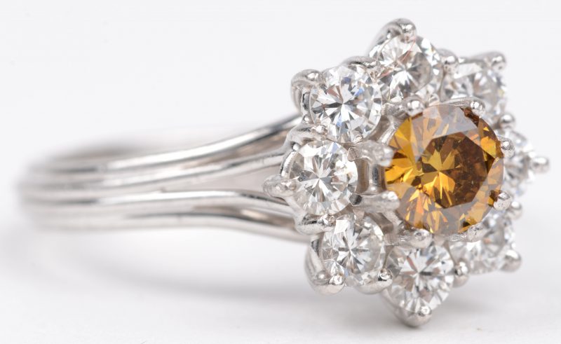 Een 18 K witgouden ring bezet met briljanten met een gezamenlijk gewicht van +- 0,80 ct. en een centrale gele diamant van +- 0,60 ct.