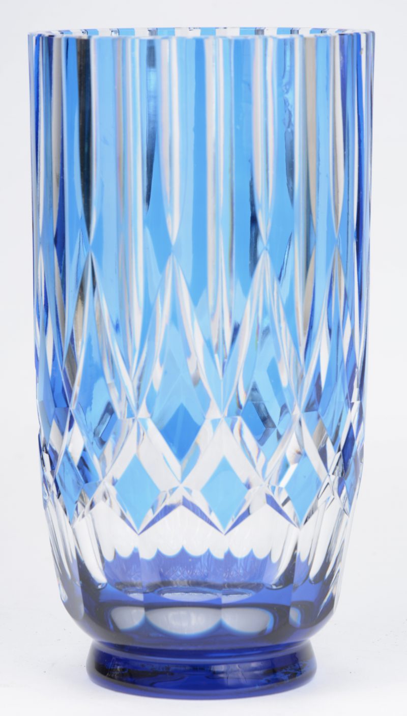 Een vaas van geslepen, blauw gedubbeld kristal. Onderaan gemerkt.  Genummerd 300 en gemonogrammeerd ‘d.v.’.