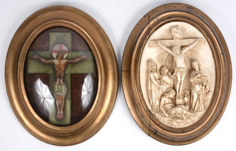 Een paar ovale kaders met beeltenissen van Christus aan het kruis, waarbij de eerste opgebouwd uit tegeltjes en de andere in gipsreliëf.