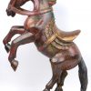Een gebeeldhouwd en gepolychromeerd houten paard.