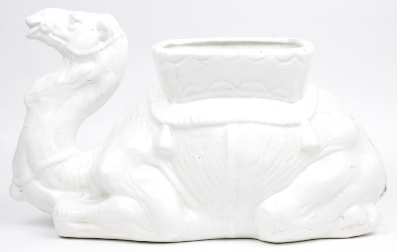 Een wit aardewerken jardinière in de vorm van een liggende kameel.