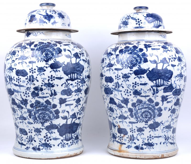 Een paar dekselvazen van Chinees porselein met een blauw op wit decor van bloemen.