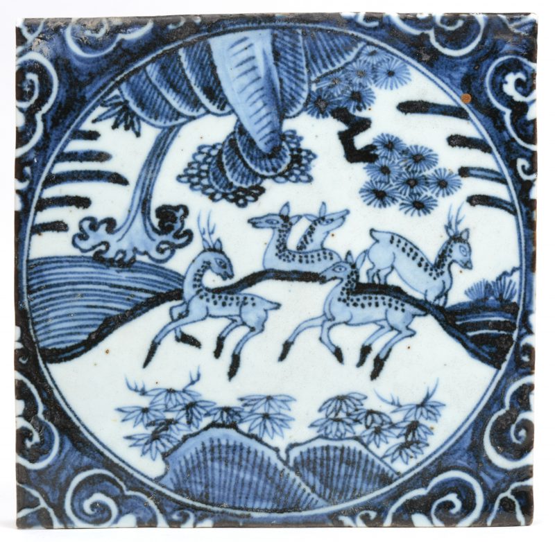 Een Aziatische tegel van blauw en wit porselein met een decor van herten.