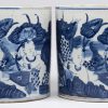 Een paar cilindervormige potten van Chinees porselein met een blauw op wit decor van zotjes.