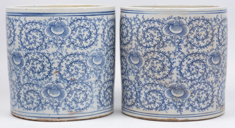 Een paar cilindervormige potten van Chinees porselein met een blauw op wit floraal decor.