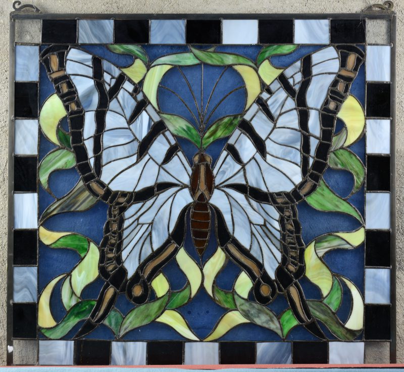 Een glas-in-loodraam met een voorstelling van een vlinder.