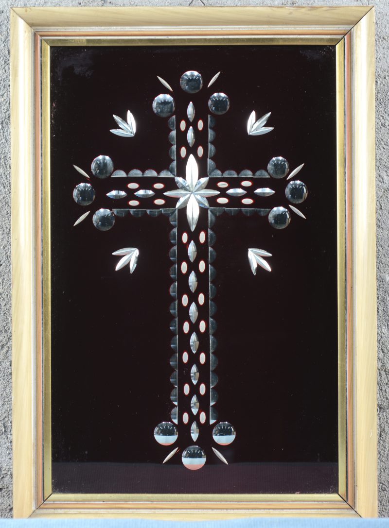 Een in rood glas ingeslepen kruis in kader.