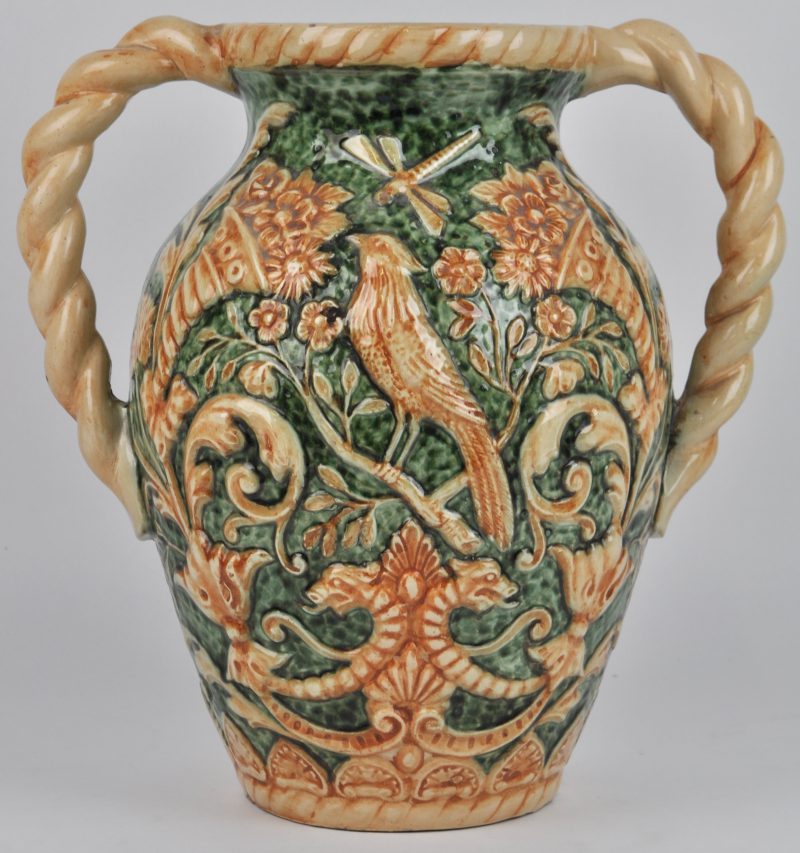 Een siervaas van beige en groen geglazuurd aardewerk met vogels en florale motieven in reliëf versierd.