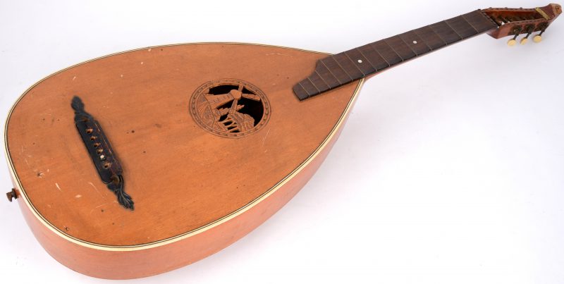 Een oude mandoline, versierd met een molentje in het klankgat. Kleine beschadiging bovenaan. Te besnaren.