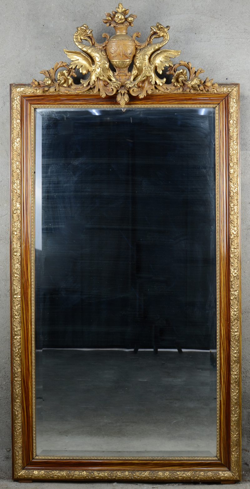 Een spiegel met verguld houten lijst, de kuif in de vorm van een siervaas, geflankeerd door twee draken. XIXe eeuw.