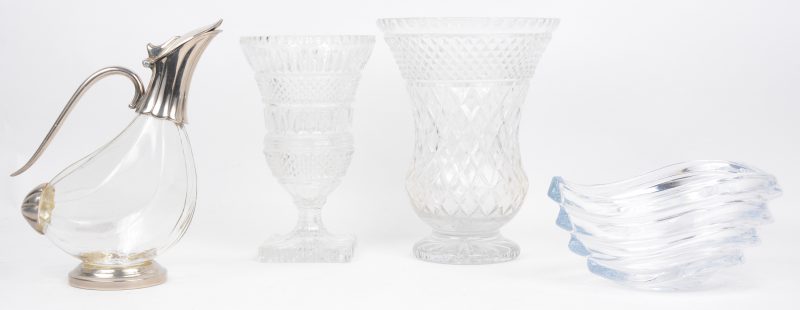 Een lot kleurloos kristal, bestaande uit twee verschillende vazen op voet, een designschaaltje en een snavelkan met verzilverd montuur. De grootste vaas met randschilfer.