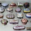 Een lot van 33 verschillende miniatuur dekseldoosjes van meerkleurig porselein. Allen gemerkt ‘Porcelain Art’ onderaan. Twee montuurtjes los. Bijgevoegd drie verschillende verzilverde pillendoosjes.