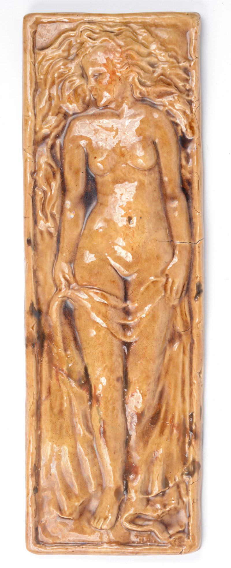Een plaquette van geglazuurd aardewerk met een vrouwelijk naakt in reliëf. Gesigneerd.
