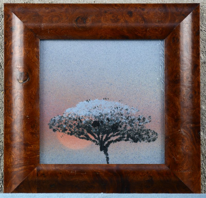Een porseleinen kunsttegel met een decor van een boom bij laaghangende zon. Onleesbaar gesigneerd. In notenhouten kader.