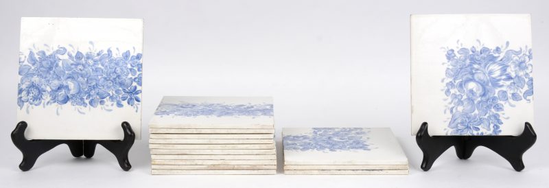 Een reeks van vijftien porseleinen tegels met een blauw bloemendecor. Belgische productie. Eén met gerestaureerd hoekje.