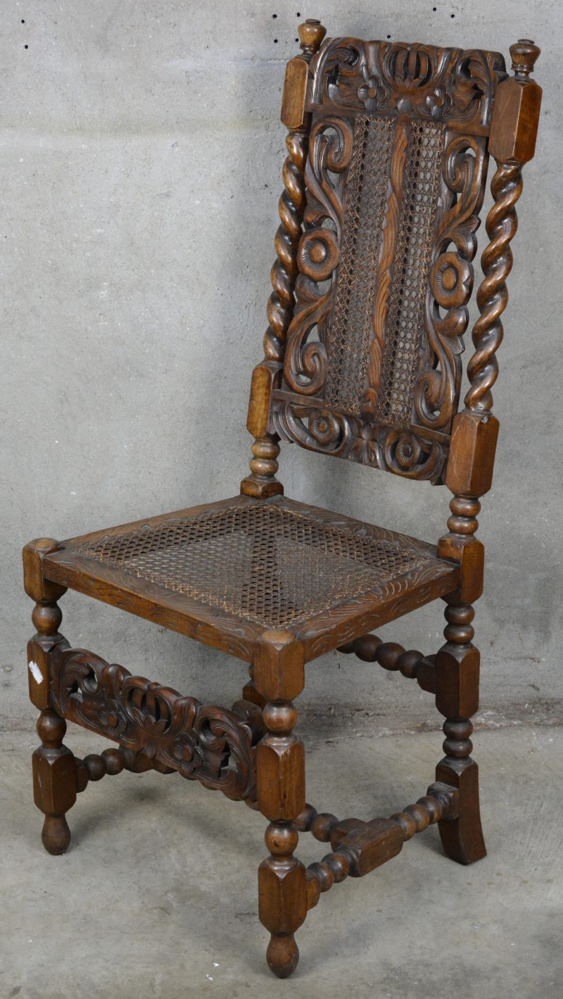 Een gebeeldhouwde stoel met gecanneerde zit en rug.