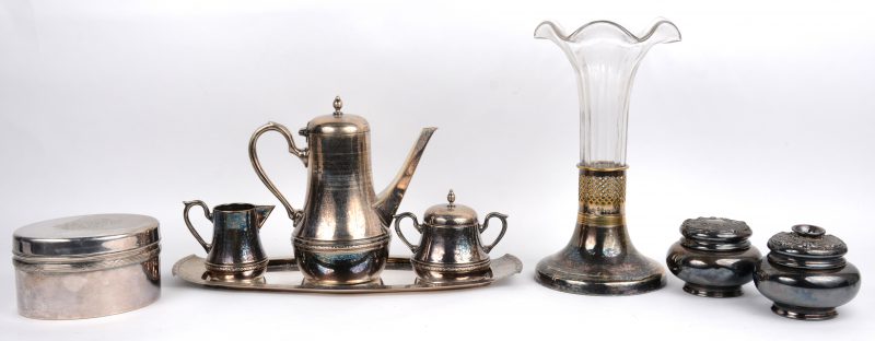 Een achtdelig lot verzilverd en wit metaal, waaronder een driedelig theestelletje op dienblad en een glazen vaas in verzilverd montuur.