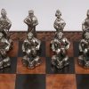 Een met leder bekleed schaakbord met metalen stukken.