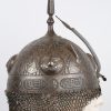 Een Perzische Kulah Khud helm met een gedamasceerd en geciseleerd decor op zwarte fond versierd. Boven op de bolle helm een vierhoekige punt en twee aigrettehouders en achteraan een maliënlap. XIXde eeuw.