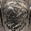 Theepot van gedreven en geciseleerd zilver versierd met bloemenfriezen rond uitsparingen met personages en dieren in acht lobben op de buik. Houten handvat. Perzië, Qadjar, begin XXste eeuw. Onderaan gemerkt 84 (840/1000) en makersmerk.