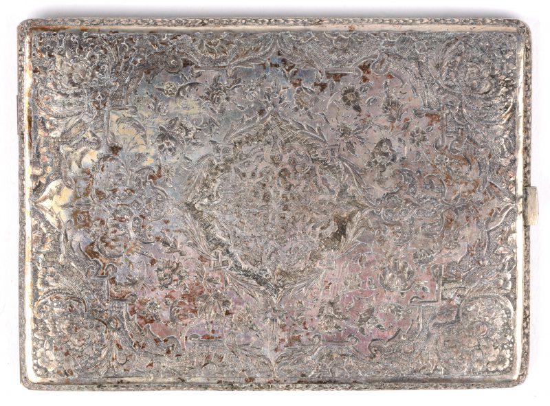 Een sigarettendoos van geciseleerd zilver versierd met arabesken rond een centraal medaillon. Zonder merken.