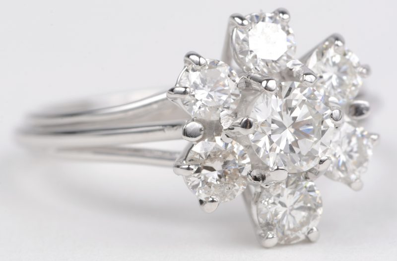Een 18 K witgouden bloemvormige ring bezet met briljanten met een gezamenlijk gewicht van +- 1,40 ct.