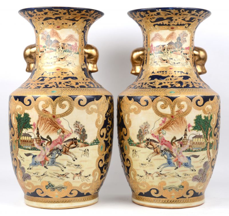Een paar vazen van Chinees porselein, versierd met meerkleurige Europese decors en vergulde motieven op kobaltblauwe fond. Apocrief gemerkt onderaan.