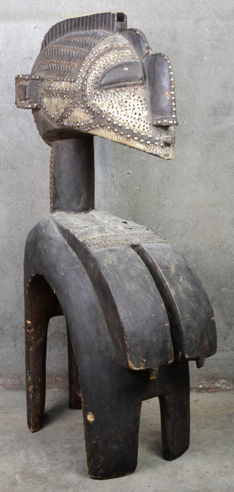 Een Afrikaans houten beeld met metalen beslag.