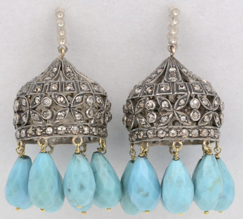 Een paar 18 K geelgouden oorbellen bezet met diamanten oude slijp in zilver gezet met een gezamenlijk gewicht van +- 1,50 ct. en druppelvormige in briolette geslepen turkoois.
