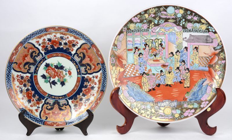 Twee grote meerkleurig porseleinen sierschotels, bestaande uit een Chinese en een japanse.