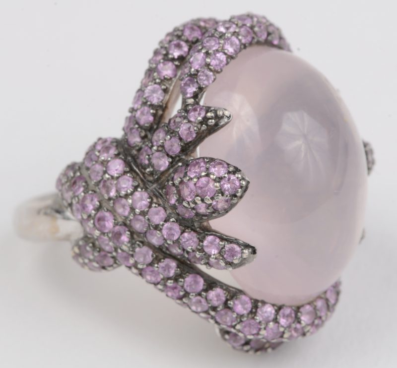 Een 18 K wit gouden ring bezet met roze saffieren en met een gezamenlijk gewicht van +- 2,50 ct. en roze maansteen van +- 12 ct.