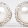 Een 18 K wit gouden ring met bijpassende oorbellen bezet met briljanten en  met een gezamenlijk gewicht van +- 2 ct. en drie parels.