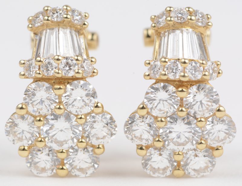 Een paar 18 K geelgouden oorbellen bezet met briljanten en diamant baguetten met een gezamenlijk gewicht van +- 3,67 ct.
