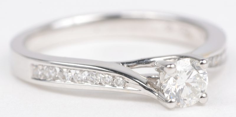 Een 18 K witgouden ring bezet met een briljanten met een gezamenlijk gewicht van +- 0,16 ct. en een centrale briljant van +- 0,33 ct. FVS2.