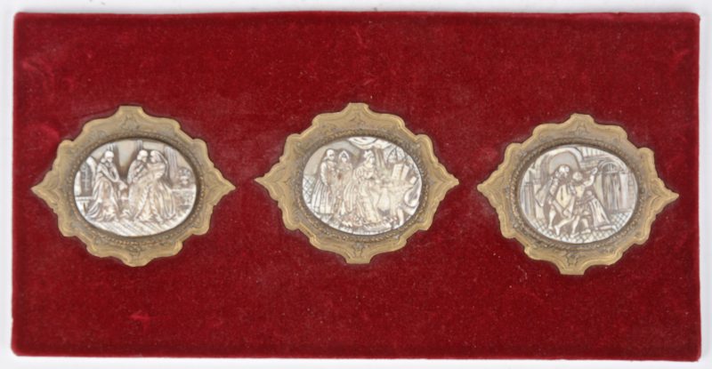 Drie ovale plaquettes van been en hoorn met historische voorstellingen in kleine koperen lijstjes. XIX eeuws.