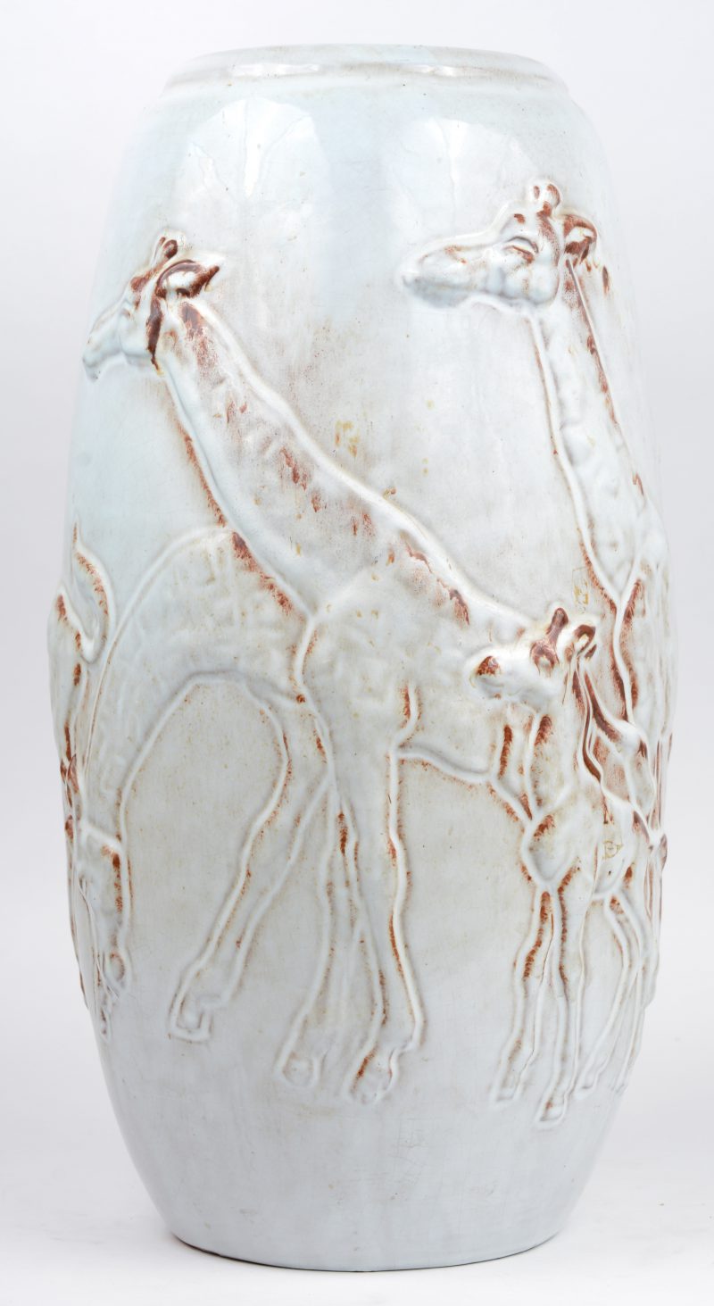 Een aardewerken vaas met een wit geglazuurd reliëfdecor van giraffen. Omstreeks 1960. Onderaan gemerkt.